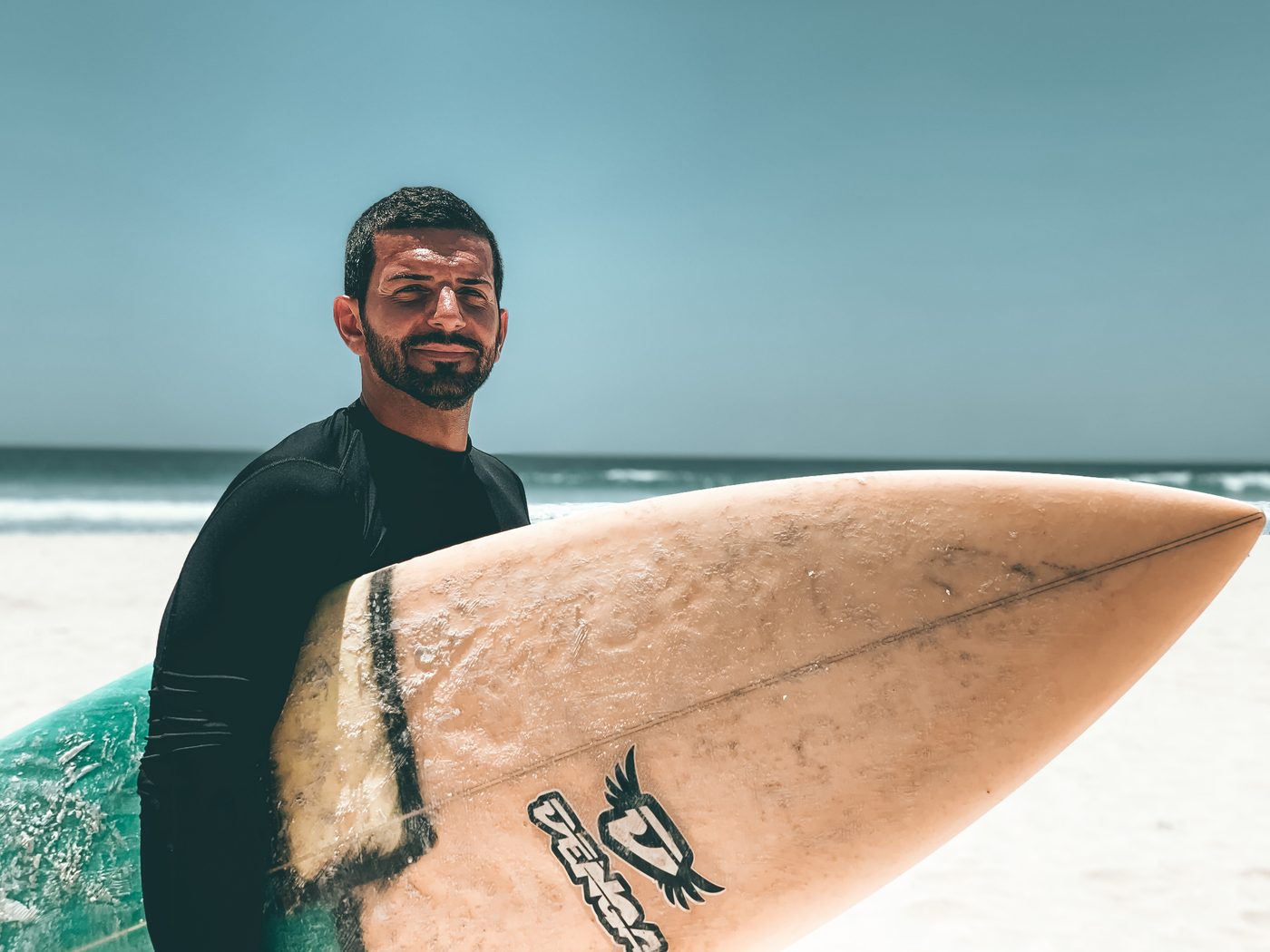 Ilias Contreas on the beach with his surfboard